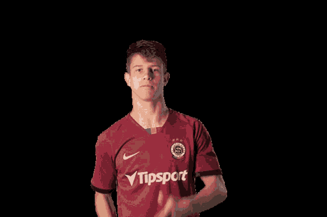 a young man wearing a red shirt with the word tipsport on it