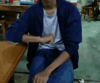 a man wearing a blue jacket and a white shirt is sitting at a table