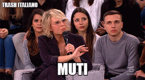 a group of people sitting on a couch with a woman holding a microphone and the word muti written above her