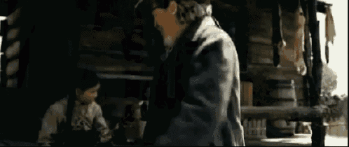 a man is standing in a dark room in a cabin .