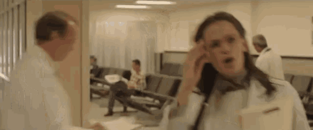 a woman is talking on a cell phone in a hospital lobby .