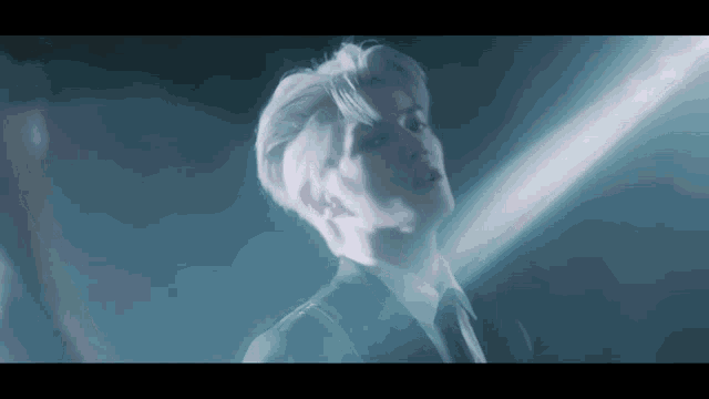a man in a suit and tie is standing in the dark