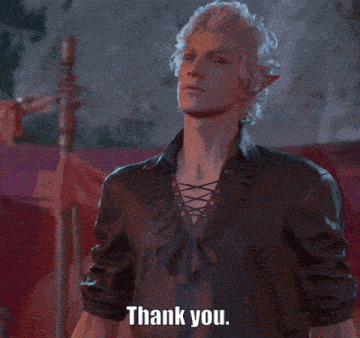 a man with blonde hair is wearing a black shirt and says thank you