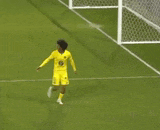 a soccer player wearing a yellow jersey and shorts is running towards the goal