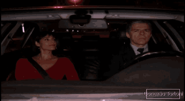 a man and a woman are sitting in a car with the words conexao tortoni on the bottom
