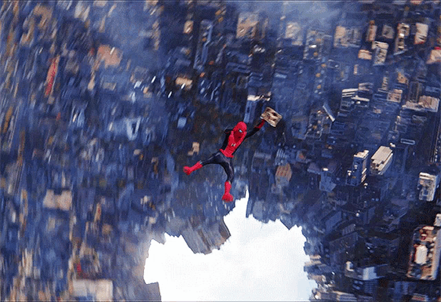 a person in a spiderman costume is flying through the air over a city