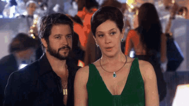a man and a woman are standing next to each other in a crowded room