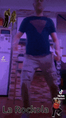 a man in a black shirt is standing in front of a pink wall with the words la rockola above him