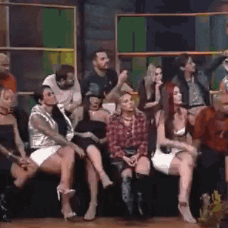 a group of people are sitting in a row on a stage watching a show .