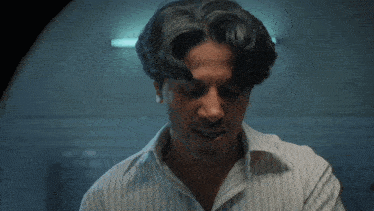 a man in a striped shirt is holding his head with his hands