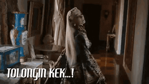 a woman in a fancy dress is standing in a hallway with the words tolongin kek below her