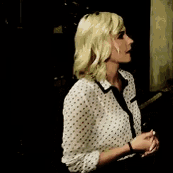 a woman with blonde hair is wearing a polka dot shirt
