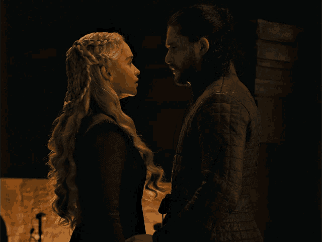 a man and a woman look at each other in the dark