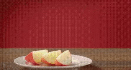 a person is spraying apple slices on a plate .