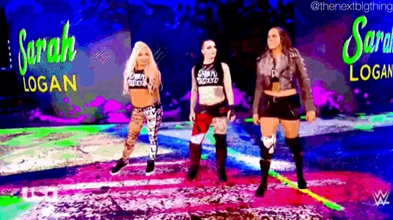 a group of women are standing next to each other on a stage in front of a sign that says sarah logan .
