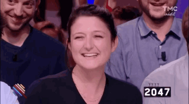 a woman is smiling in front of a sign that says 2047 on it .