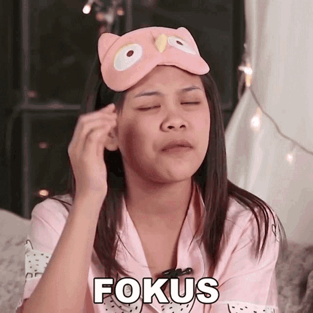 a woman wearing an owl mask has the word fokus written on her face