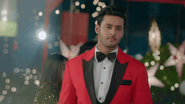 a man in a red tuxedo with a black bow tie
