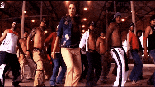 a group of people are dancing in front of a sign that says ' mals studios '