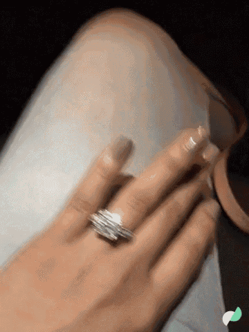 a woman 's hand with a diamond ring on it