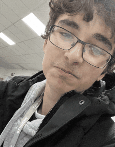a man wearing glasses and a lanyard with the word student on it