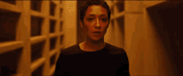 a woman in a black shirt is standing in a hallway