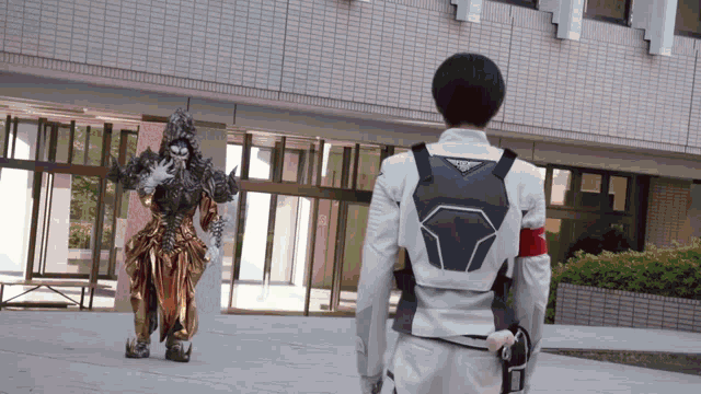a man in a white jacket stands in front of a building with a monster in a gold costume
