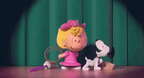 a girl is standing next to a dog on a stage .