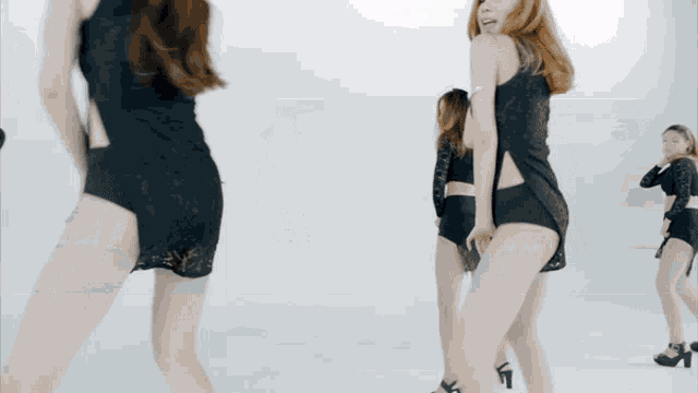 a group of women are dancing in front of a white backdrop