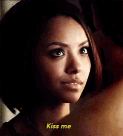 a woman is looking at a man and saying kiss me .