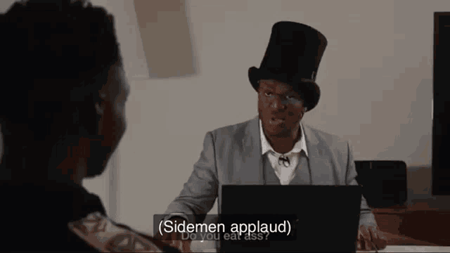 a man in a top hat talks to another man