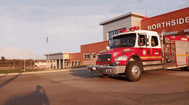 a red fire truck is parked in front of the northside fire station