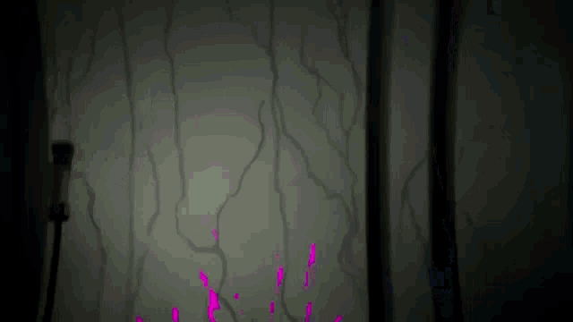 a dark room with a purple light coming out of the corner