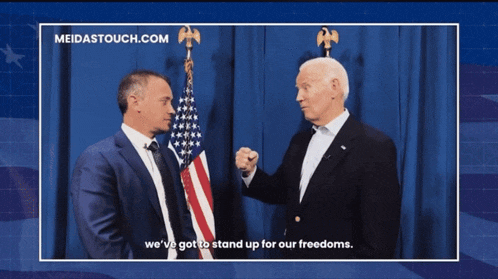 two men are standing in front of an american flag and the website meidastouch.com is visible in the corner