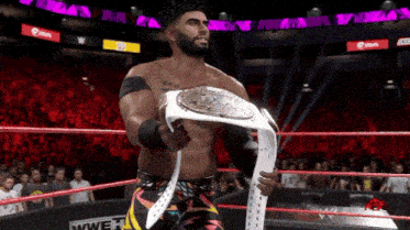 a man in a wrestling ring is holding a championship belt