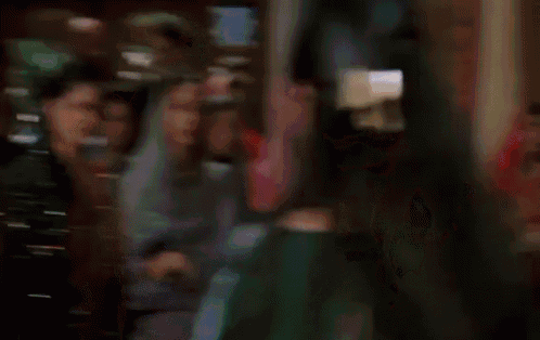 a woman in a red dress is dancing in front of a crowd of people .