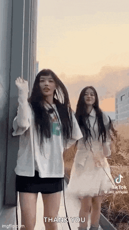 a couple of girls are standing next to each other and dancing .