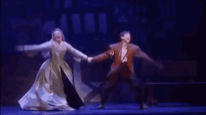 a man and woman are dancing on a stage in a play .