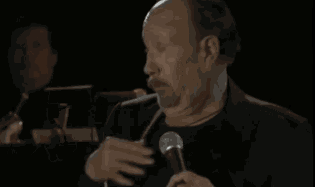 a man is holding a microphone and making a face