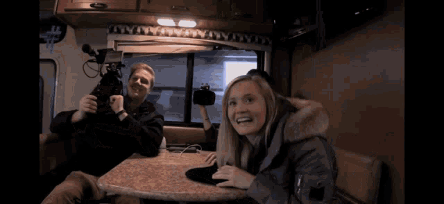 a man and a woman sitting at a table in a rv