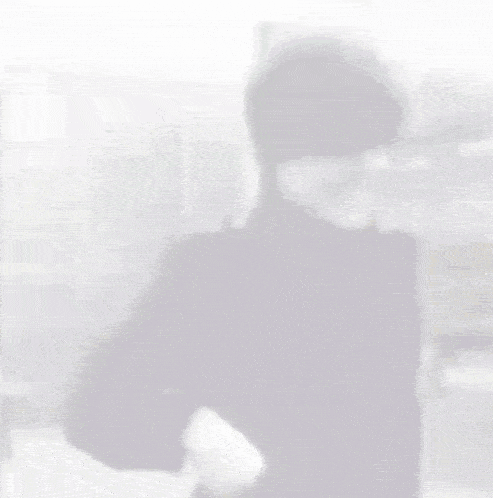 a blurred image of a man wearing sunglasses and a black jacket