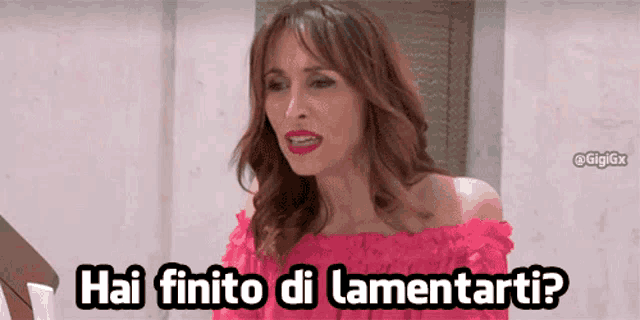 a woman in a pink off the shoulder top is asking " hai finito di lamentarti "