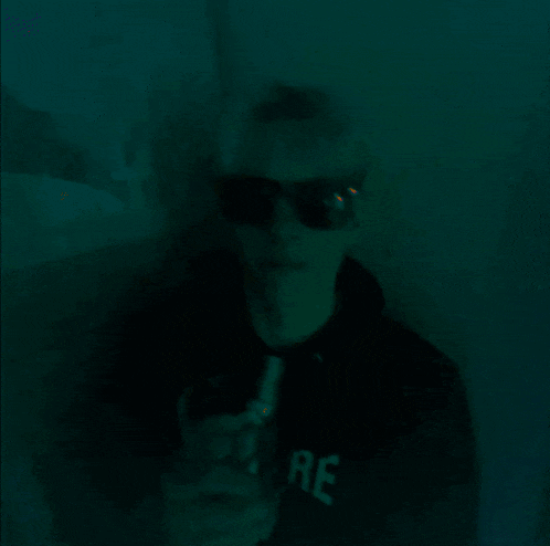 a person wearing sunglasses and a black shirt that says ' allure '