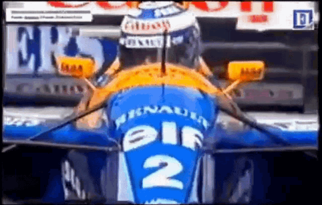 a man is driving a blue and orange race car with the number 2 on the back .