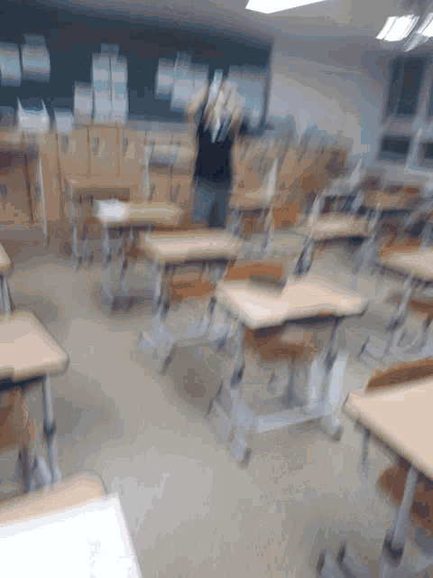 a blurry picture of an empty classroom with a green board that says ' a ' on it