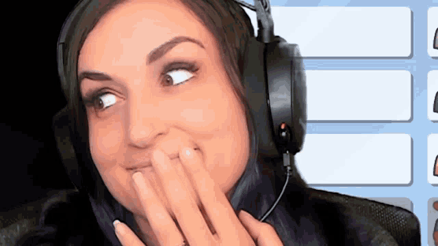 a woman wearing headphones is covering her mouth