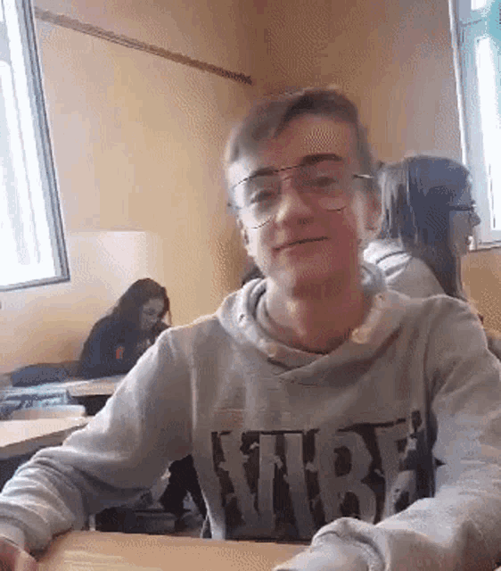 a boy wearing glasses and a sweater that says nike