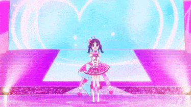 a girl in a pink dress is standing on a stage in front of a heart shaped screen .