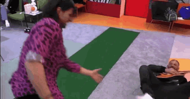 a man is playing a guitar while a woman is dancing in a room .
