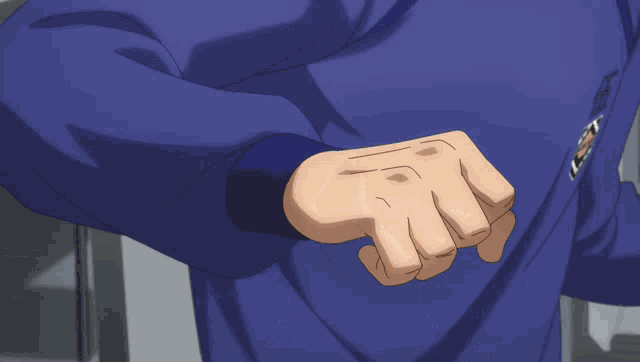a man in a blue shirt holds his fist up in the air